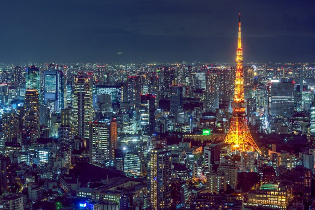 Stunning aerial view of Tokyos vibrant cityscape with the illuminated Tokyo Tower at night.